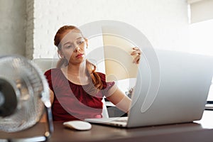 Businesswoman Sweating At Work With Broken Conditioner