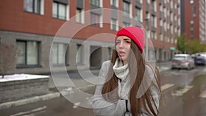 Portrait of a young sad beautiful woman, a girl walking in cold weather in rainy day at city street outdoors, autumn