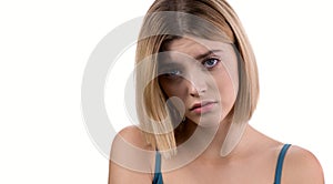 Portrait of young sad woman looks to the camera, isolated on white