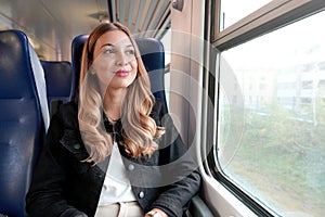 Portrait of young satisfied woman traveling with public transport sitting relaxed thoughtless