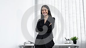 Portrait of young secretary woman standing with crossed arms and looking at the camera