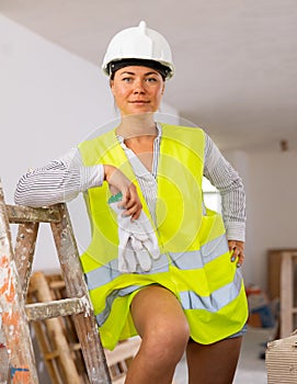 Portrait of a young seductive woman in a vest posing in an apartment