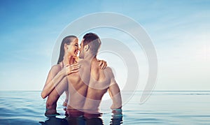 Portrait of a young, sensual couple relaxing in a tropical pool