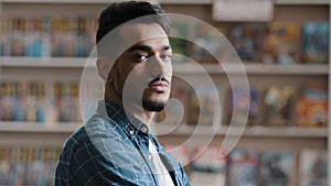 Portrait of young serious arabic model man with beard in plaid shirt standing indoors posing looking at camera close-up