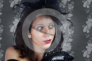 Portrait of young woman in black veil on vintage background
