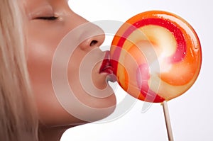 Portrait of young woman kissing lollipop