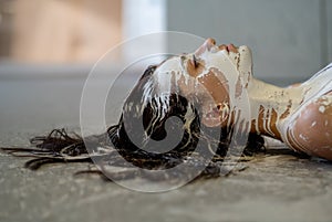 Portrait of a young, sexy woman in white color painted decorative, lies on the floor in the studio. Creative expressive abstract