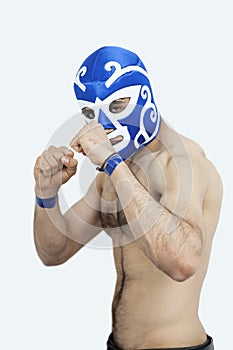 Portrait of a young shirtless male wrestler over gray background