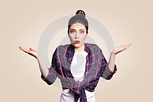 Portrait of young shocked brunette woman with casual style looking desperate or panic, keeping mouth open