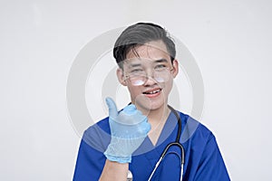 Portrait of a young and skilled medical student, nurse, intern posing with one thumbs up. Isolated on a white background