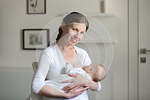 Portrait of a young smiling attractive woman breastfeeding a chi