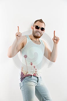 Portrait of young smiling bearded man in sunglasses showing thumbs up