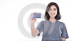 Portrait of young smiling beautiful Asian woman presenting credit card in hand showing trust and confidence making payment.