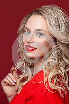 Portrait of young smiling blonde woman looks in camera