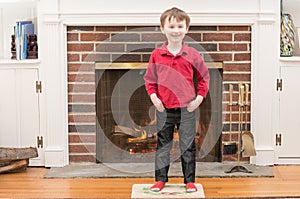 Portrait of a young smiling boy in front of a fireplace dressed for valentine`s day