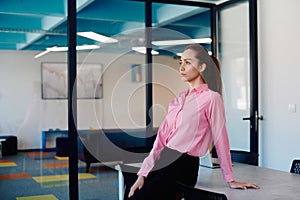 Portrait of young smiling business woman in creative open space coworking startup office. Successful businesswoman