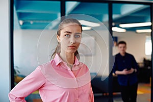 Portrait of young smiling business woman in creative open space coworking startup office. Successful businesswoman