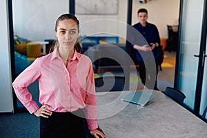 Portrait of young smiling business woman in creative open space coworking startup office. Successful businesswoman