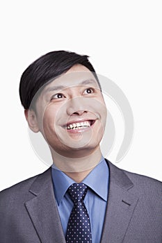 Portrait of young smiling businessman looking up, studio shot