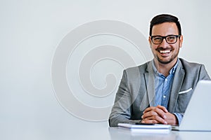 Portrait of young smiling cheerful businessman in office looking at camera copy space