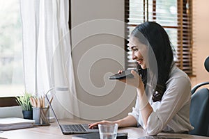 Portrait of a young, smiling, and cheerful entrepreneur working in a casual office, effortlessly multitasking by making