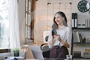 Portrait of a young, smiling, and cheerful entrepreneur working in a casual office, effortlessly multitasking by making