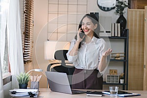 Portrait of a young, smiling, and cheerful entrepreneur working in a casual office, effortlessly multitasking by making