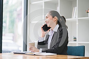 Portrait of a young, smiling, and cheerful entrepreneur working in a casual office, effortlessly multitasking by making