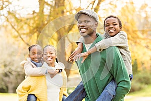 Portrait of a young smiling family in piggyback