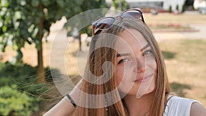 Portrait of a young smiling girl in the park on a summer day.