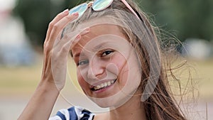 Portrait of a young smiling girl in the park on a summer day.