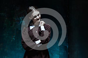 Portrait of a young smiling girl in school uniform as killer woman