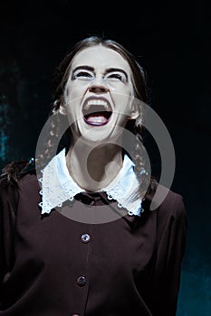 Portrait of a young smiling girl in school uniform as killer woman