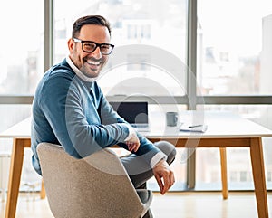 Portrait of young smiling happy handsome successful businessman entrepreneur freelancer working looking back