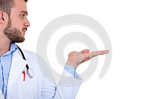 Portrait of a Young smiling male doctor pointing finger away isolated on a white background