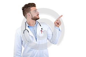 Portrait of a Young smiling male doctor pointing finger away isolated on a white background