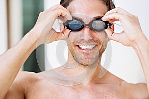 Portrait of young smiling male swimmer in googles
