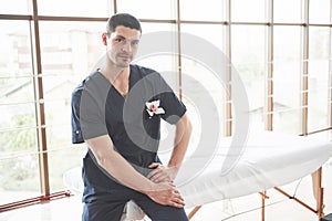 Portrait of young smiling man in uniforme near massage couches photo