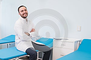 Portrait of young smiling man in uniforme near massage couches photo