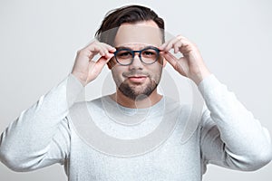 Portrait of young smiling man wearing blue glasses over white background