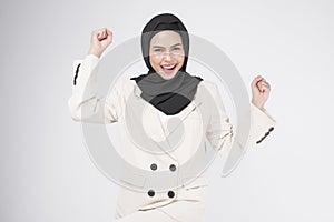 Portrait of young smiling muslim businesswoman wearing suit with hijab over white background studio