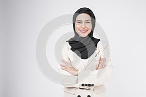 Portrait of young smiling muslim businesswoman wearing suit with hijab over white background studio