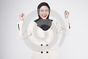 Portrait of young smiling muslim businesswoman wearing suit with hijab over white background studio