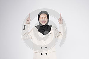 Portrait of young smiling muslim businesswoman wearing suit with hijab over white background studio