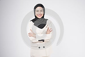 Portrait of young smiling muslim businesswoman wearing suit with hijab over white background studio