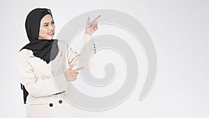 Portrait of young smiling muslim businesswoman wearing suit with hijab over white background studio