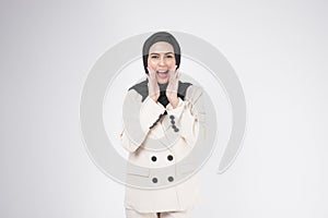 Portrait of young smiling muslim businesswoman wearing suit with hijab over white background studio