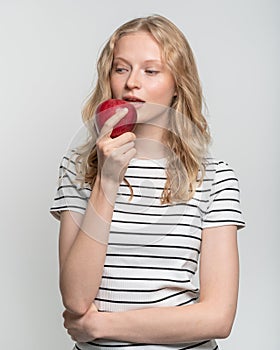 Portrait of young smiling woman bitting red apple. Fresh face, natural beauty