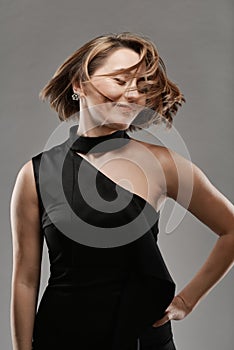 Portrait of young smiling woman in black dress