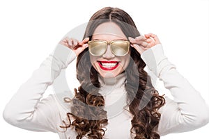 Portrait of young smiling woman with bright makeup wearing gold opaque sunglasses,